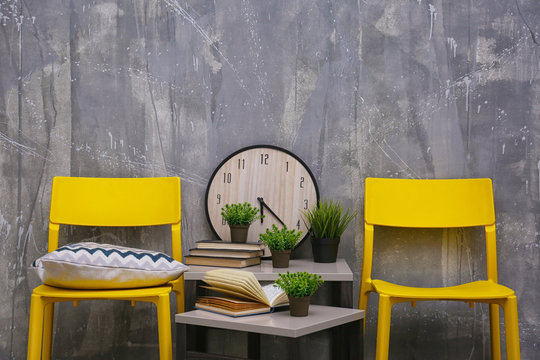 Modern interior design with yellow chairs and little table on grey background