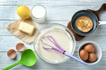 Ingredients for preparation of pancakes, on wooden background