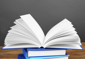 Pile of books on wooden table and grey background