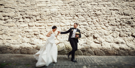 Stone wall and positive newlyweds