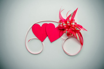 two red hearts and ribbon on white background 