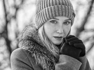 Black and white portrait of young woman at sunny winter day.
