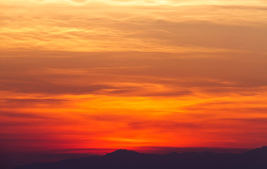 Fototapeta na wymiar Dramatic sunset setting above mountain