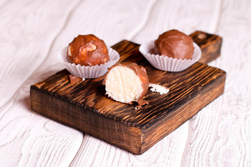 Handmade chocolate coconut candy on wooden table