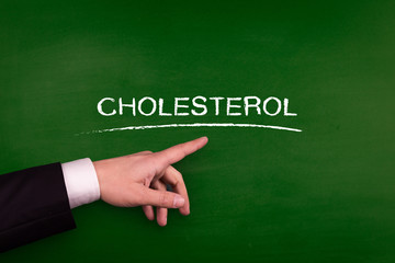 Businessman pointing CHOLESTEROL word on blackboard