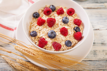 Oatmeal being garnished with fresh berries