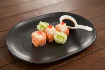 Three nigiri sushi served with soy sauce in black plate