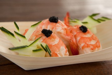Three nigiri sushi served in wooden boat plate