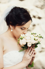 Portrait of the beautiful brunette bride with a bouquet