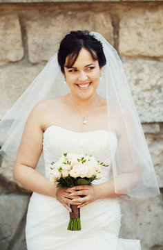 Charming smile of the bride with the beautiful bouquet