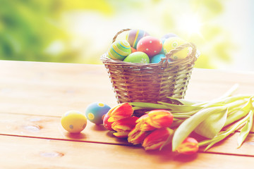 close up of easter eggs in basket and flowers