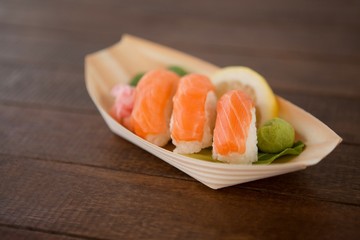 Three nigiri sushi served in wooden boat plate