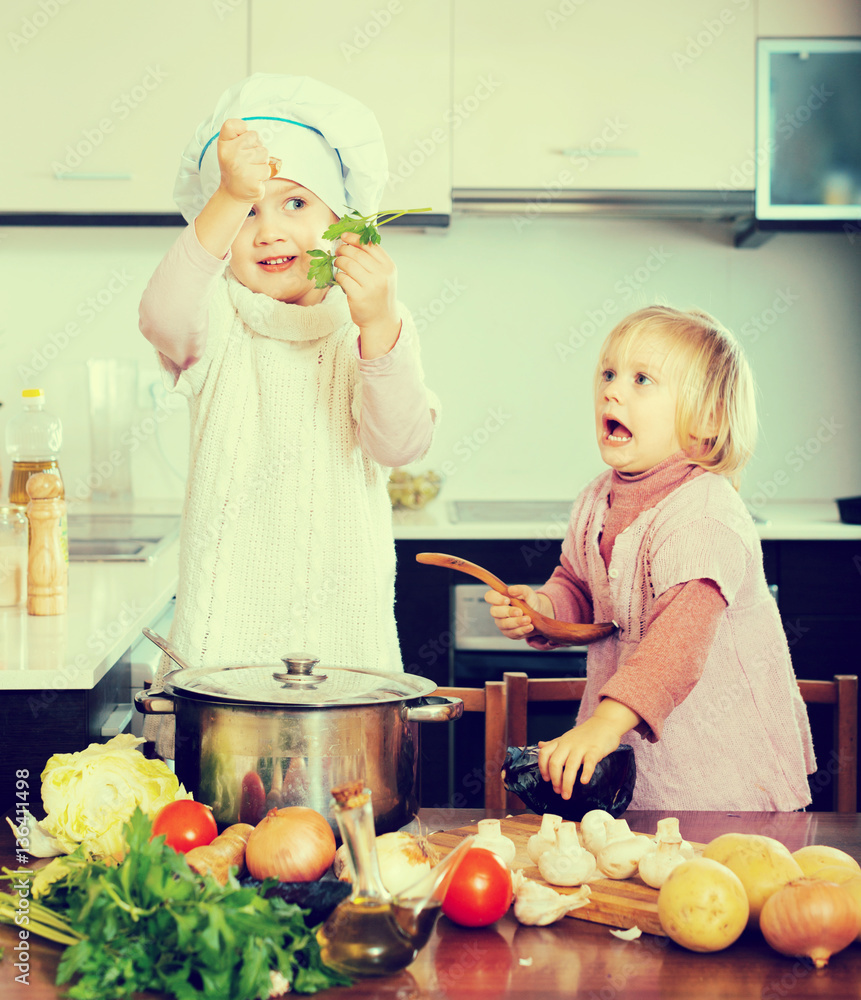 Wall mural Two little sisters at home kitchen