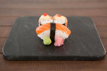 Nigiri and uramaki sushi served on black stone slate