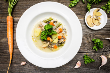 Top View Vegetable Soup with Carrot, Mushrooms, Parsley Leaves, Garlic and Potatoes