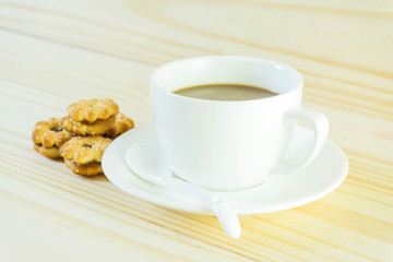 Coffee cup and candy on wood table background.