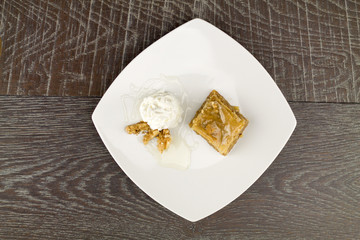 baklava and white yogurt on wooden table