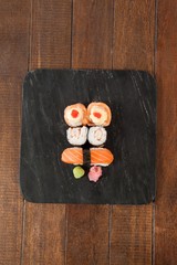 Nigiri and uramaki sushi served on black stone slate
