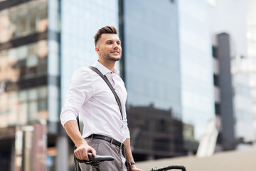 young man with bicycle on city street