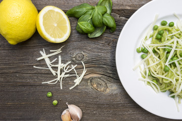 Spaghetti Pasta with Peas, Cut Lemon. Fresh Basil Leaves, Garlic and Cheese on Wooden Background