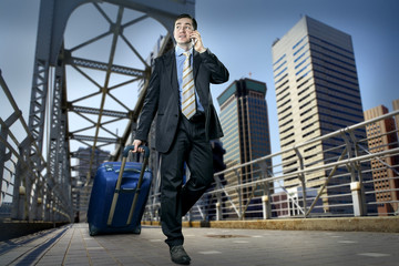 Man with baggage speaking by phone on the bridge