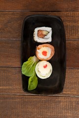 Nigiri and uramaki sushi served on black boat plate