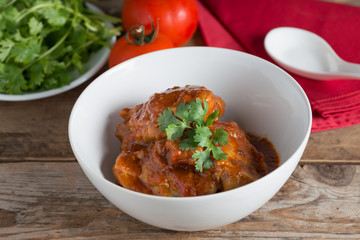 Chicken with sauce tomato in white bowl.