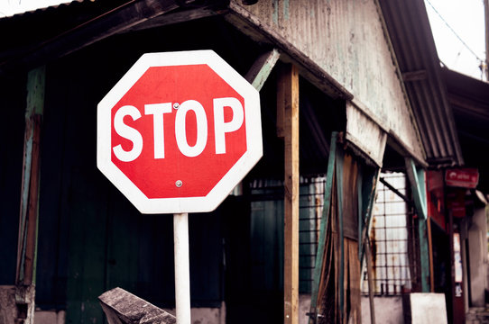 Stop sign against the backdrop of dilapidated housing