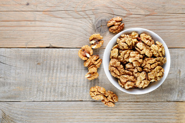 Walnuts in bowl on wooden table top view - 136415614
