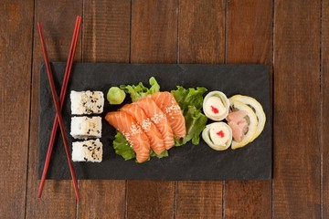 Uramaki, sashimi and nigiri sushi served with chopsticks