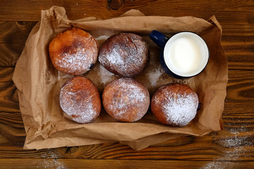 Donuts wrapped in a paper on wood background. Top view point.