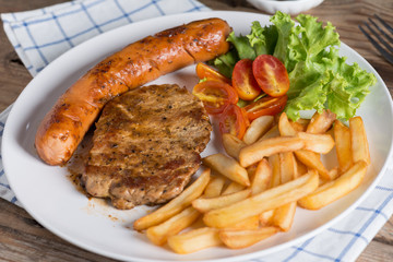 Close up, Roasted beef meat steak and sausage with french fries.