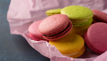 Colorful macaroons. Sweet macarons over blue background with copy space. Selective focus