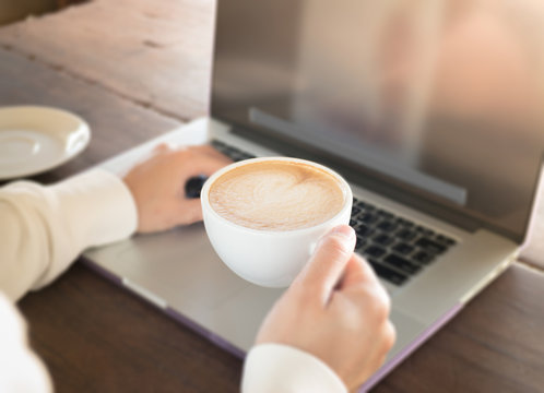 Woman working with laptop and hot coffee