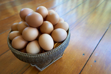 Basket on eggs on wooden floor