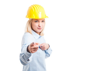 Lady engineer wearing yellow pointing at camera