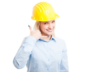 Female architect wearing helmet showing call me gesture
