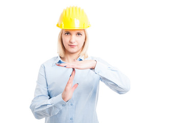 Female architect wearing helmet showing time out gesture