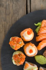 Set of assorted sushi served on black stone slate
