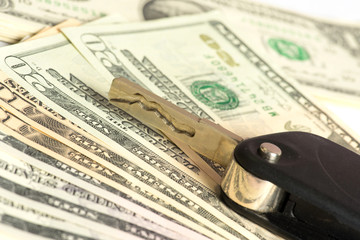 Ein Autoschl&uuml;ssel und Dollar Geldscheine