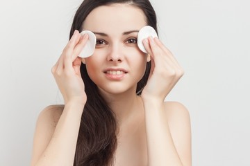 Fototapeta premium happy brunette with two cotton balls near the face