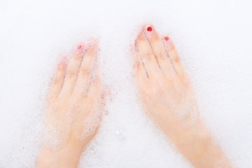 Childs hands in shampoo foam in bath. Healthcare and hygiene concept.