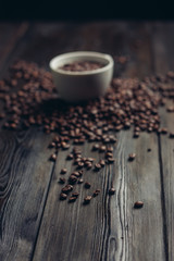 cup with coffee beans scattered on the table