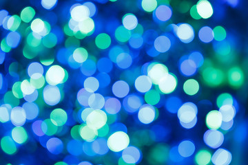 Fototapeta premium Blurred lights blue background. Glittering christmas effect. Abstract colorful pattern. Shimmering blur spots. Festive design.