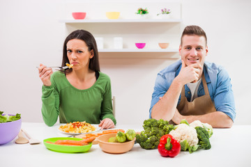 Young couple cooking in their kitchen.