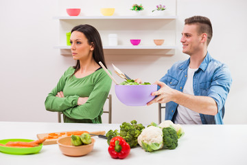 Young couple cooking in their kitchen.