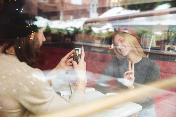 Portrait of haapy hipsters in cafe behind the glass