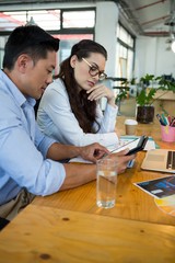 Graphic designers discussing over digital tablet