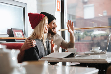 Side view of happy hipsters with laptop