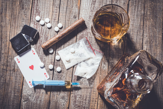Hard Drugs And Alcohol On An Old Wooden Table